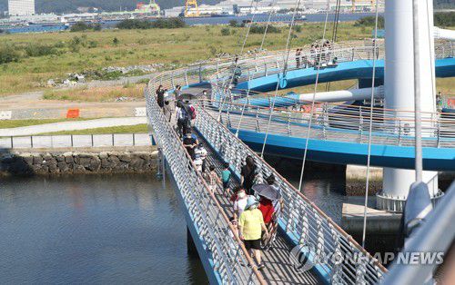 마산해양신도시 산책로 임시개방(창원=연합뉴스) 김동민 기자 = 지난달 22일 오후 많은 시민이 경남 창원시 마산합포구 서항지구 친수공간·마산해양신도시 수변 산책로를 연결하는 보도교를 걷고 있다. [연합뉴스 자료사진]