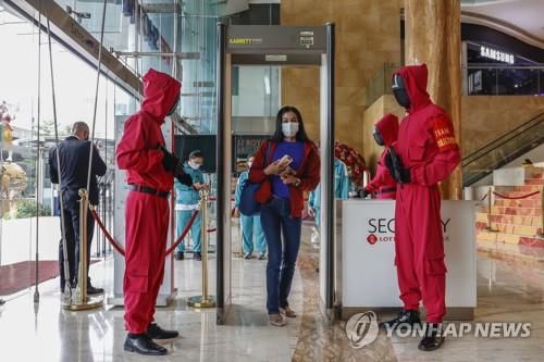 '오징어게임' 빨간색 경비원복 차림으로 고객맞이[EPA=연합뉴스]