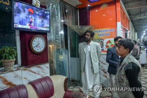 카불에서 아프간 크리켓팀 경기를 지켜보는 주민 (카불 AFP=연합뉴스)  25일(현지시간) 아프가니스탄 수도 카불에서 T20 크리켓 월드컵 아프가니스탄-스코틀랜드전을 지켜보는 주민.  2021.10.25. photo@yna.co.kr