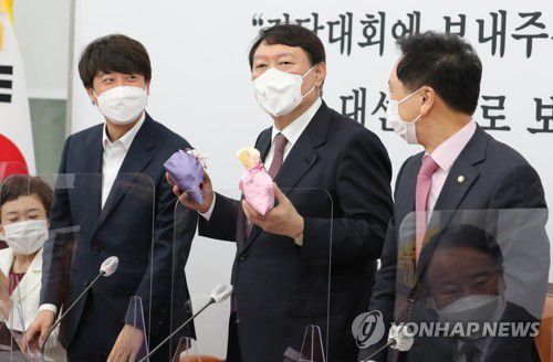 비단주머니 받고 발언하는 윤석열 대선후보(서울=연합뉴스) 하사헌 기자 = 국민의힘 윤석열 대선후보(가운데)가 8일 오전 서울 여의도 국회에서 열린 최고위원회의에서 이준석 대표(왼쪽)로부터 비단주머니를 받고 발언하고 있다. 2021.11.8 [국회사진기자단] toadboy@yna.co.kr