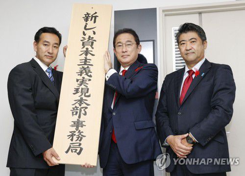 핵심 정책 간판 내거는 기시다기시다 후미오(岸田文雄)·가운데 일본 총리가 지난달 15일 도쿄에서 '새로운 자본주의 실현 본부 사무국' 간판을 걸고 있다. [도쿄 교도=연합뉴스 자료사진]