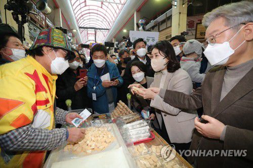 물건 사는 이재명 대선후보 부부(청주=연합뉴스) 백승렬 기자 = 더불어민주당 이재명 대선후보가 21일 부인 김혜경 씨와 함께 충북 청주시 상당구 육거리종합시장을 방문, 물건을 사고 있다. 2021.11.21 srbaek@yna.co.kr