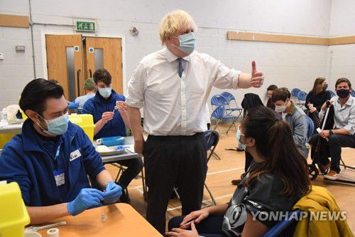 오미크론 확산 속 부스터샷 접종자 격려하는 존슨 영국 총리(런던 로이터=연합뉴스) 보리스 존슨(중앙) 영국 총리가 13일(현지시간) 런던 웨스트민스터의 신종 코로나바이러스 감염증(코로나19) 백신 접종소를 방문해 엄지손가락을 치켜세우며 3차 접종(부스터샷)을 하는 시민들을 격려하고 있다. 존슨 총리는 전날 TV를 통한 대국민 연설에서 '오미크론 비상사태'에 대응하기 위해 이달 말까지 18세 이상 성인에게 부스터샷을 제공하겠다며 모두 백신접종에 나설 것을 호소했다. 2021.12.13 sungok@yna.co.kr
