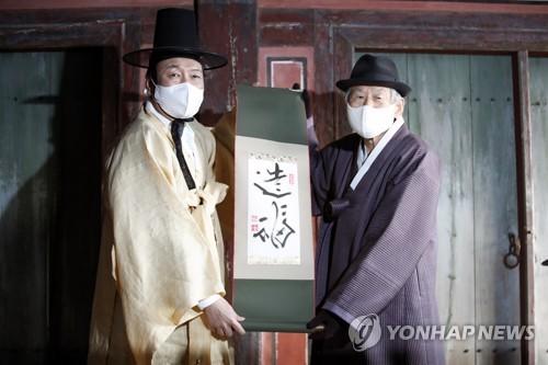 윤석열, 도산서원 방문(안동=연합뉴스) 이정훈 기자 = 국민의힘 윤석열 대선 후보가 29일 오후 경북 안동시 도산서원을 찾아 퇴계 이황 16대 종손 이근필 선생의 '조복' 글귀를 선물 받고 있다. 2021.12.29 [공동취재] uwg806@yna.co.kr