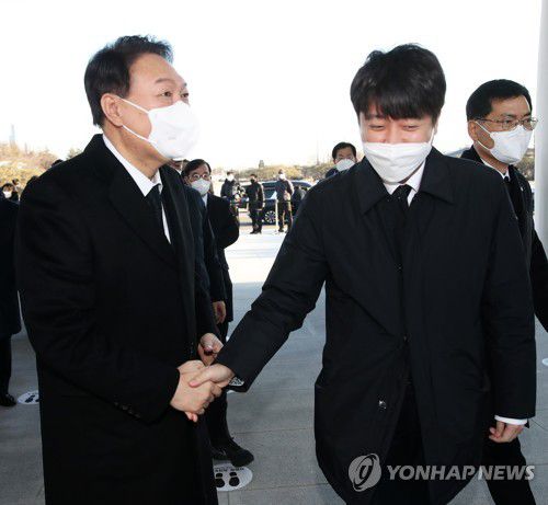 악수하는 윤석열·이준석(서울=연합뉴스) 이정훈 기자 = 국민의힘 윤석열 대선 후보와 이준석 대표가 1일 오전 서울 동작구 국립서울현충원을 참배하기 전 만나 악수하고 있다. 2022.1.1 uwg806@yna.co.kr