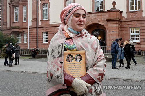 코블렌츠 고등법원 앞에서 시리아에서 사망한 친척들의 사진을 가슴에 안은 시리아 여성[EPA 연합뉴스 자료사진 재배포 및 DB 금지]