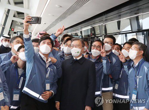 사우디아라비아를 공식방문 중인 문재인 대통령이 19일(현지시간) 삼성물산의 리야드 지하철 건설현장인 프린세스 노라 여자대학 1번역을 방문, 현장 근로자들을 격려한 뒤 기념촬영을 하고 있다.  2022.1.19 [연합뉴스 자료사진]