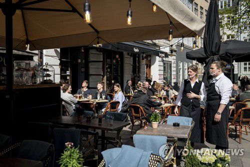 지난해 4월 덴마크 코펜하겐 식당 야외에서 사람들이 앉아있다. [EPA 연합뉴스 자료사진. 재판매 및 DB 금지]