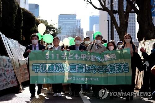 집단 소송 제기하는 일 후쿠시마 원전 피해자들 (도쿄 AFP=연합뉴스) 일본 후쿠시마 제1원전 사고 당시 주변 지역에 거주하던 청년 6명의 변호인과 후원인들이 지난달 27일 원전 운영사인 도쿄전력을 상대로 손해배상청구 소송을 제기하기 위해 도쿄지방법원으로 이동하고 있다. 원고 측은 2011년 사고 당시의 방사성 물질 누출로 갑상샘암에 걸렸다며 총 60억원대의 배상을 요구하고 있다. 2022.1.27 jsmoon@yna.co.kr