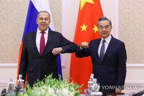 러·중 외교 장관[타슈켄트 EPA=연합뉴스 자료사진] 우즈베키스탄 수도 타슈켄트에서 2021년 7월15일(현지시간) 회동한 세르게이 라브로프(왼쪽) 러시아 외무장관과 왕이(오른쪽) 중국 외교부장이 '팔꿈치 인사'를 나누고 있다. [러시아 외무부 제공. 판매 금지] sungok@yna.co.kr