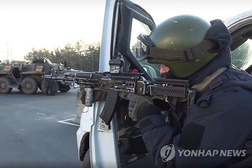 러시아 국방부가 공개한 우크라이나 체르노빌 원자력 발전소 시설에서 무장한 채 주변을 경계하는 병사의 모습. [타스 연합뉴스, 재판매 및 DB 금지]]