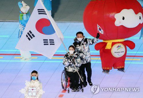 [패럴림픽] 기수 맡은 '장윤정 고백'팀 리드 백혜진(베이징=연합뉴스) 김주성 기자 = 4일 오후 중국 베이징 국립경기장에서 열린 2022 베이징 패럴림픽 개회식에서 대한민국 선수단의 기수를 맡은 휠체어컬링 대표팀 '장윤정 고백'의 리드 백혜진이 태극기를 앞세우고 입장하고 있다.       대한민국 선수단 32명은 6개 전 종목에 출전해 인간 승리에 도전한다. 2022.3.4 utzza@yna.co.kr