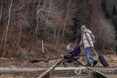 '유모차 밀며'…폴란드 국경 넘는 우크라 여성 피란민(크로스치엔코 AFP=연합뉴스) 3일(현지시간) 폴란드 국경 마을 크로스치엔코에서 한 우크라이나 여성이 유모차를 밀며 걸어서 국경을 넘고 있다. 유엔난민기구(UNHCR)에 따르면 지난달 24일 우크라이나를 침공한 러시아군이 공세를 강화하면서 우크라이나 주민 100만여 명이 이웃 국가로 피신한 것으로 집계됐다. 2022.3.4 sungok@yna.co.kr