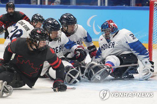 [패럴림픽] 퍽에 쏠린 시선(베이징=연합뉴스) 김주성 기자 = 8일 오후 중국 베이징 국립실내체육관에서 열린 2022 베이징 동계패럴림픽 장애인아이스하키 A조 예선 한국 대 캐나다 경기에서 이준용, 조영재와 캐나다 제임스 던 등 선수들의 시선이 골문으로 향하는 퍽에 쏠리고 있다. 2022.3.8 utzza@yna.co.kr