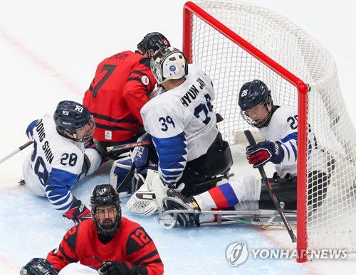 [패럴림픽] 골대 절대사수(베이징=연합뉴스) 김주성 기자 = 11일 오후 중국 베이징 국립실내체육관에서 열린 2022 베이징 동계패럴림픽 장애인아이스하키 준결승전 한국 대 캐나다 경기. 한국 장동신(20), 골리 최혁준, 이종경(28)이 캐나다 잭 라빈의 슛을 낙아내고 있다. 2022.3.11 utzza@yna.co.kr