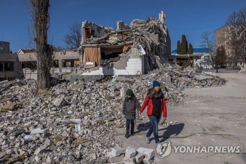 러시아의 무차별 폭격에 부서진 우크라이나 학교(지토미르 EPA=연합뉴스) 20일(현지시간) 우크라이나 키이우(키예프) 서쪽 도시 지토미르에서 러시아군의 무차별 폭격으로 심하게 부서진 학교 건물 잔해 옆으로 한 여성이 소년의 손을 잡고 걸어가고 있다.