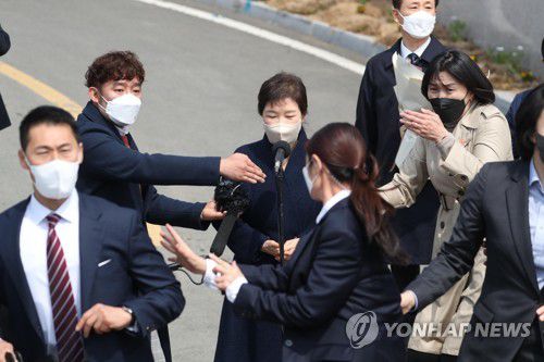 급박한 순간(대구=연합뉴스) 김현태 기자 = 24일 오후 박근혜 전 대통령이 대구 달성군 사전에 도착해 대국민 담화문을 밝히던 중 갑자기 소주병이 날아들자 경호원들이 박 전 대통령을 에워싸고 있다. 2022.3.24 mtkht@yna.co.kr