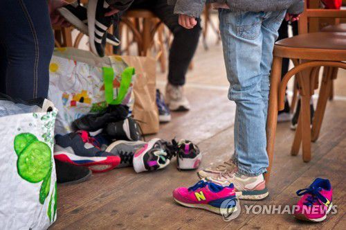 기증 받은 신발을 신어보는 우크라이나 피란민들[AFP 연합뉴스 자료사진. 재판매 및 DB 금지]