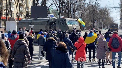 지난달 20일(현지시간) 우크라이나 헤르손에서 우크라이나 국기를 들고 러시아군에 항의하는 시위대 [로이터=연합뉴스 자료사진. 재판매 및 DB 금지]