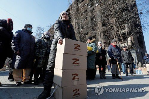 'Z' 표시 구호품 상자 주변의 마리우폴 주민(마리우폴 로이터=연합뉴스) 러시아가 지난 2월 24일 우크라이나 침공 직후부터 집중적으로 공격해 대부분 지역을 장악한 남부 항구도시 마리우폴에서 5일(현지시간) 'Z' 표시가 된 구호품 상자 주변으로 주민들이 몰려 있다. 'Z' 표시는 러시아의 우크라이나 침공 전쟁을 지지하는 상징으로 사용되고 있다. 2022.4.6 leekm@yna.co.kr