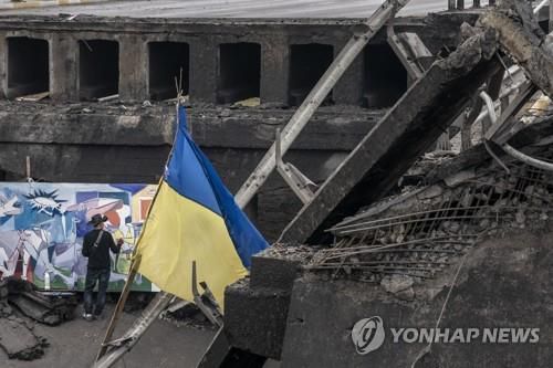 지난 22일 우크라이나 수도 키이우 근처 이르핀 타운에서 파괴된 다리 옆 벽화 작업[UPI 연합뉴스 자료사진. 재판매 및 DB 금지]