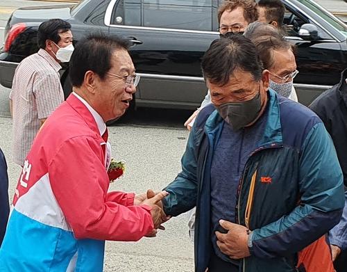 유권자와 인사 나누는 송인헌 괴산군수 후보[연합뉴스 자료사진]