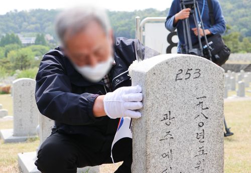 희생자 묘비 어루만지는 5·18 운동 당시 가해자(서울=연합뉴스) 5·18 민주화 운동 당시 고속버스를 몰아 경찰저지선으로 돌진, 경찰 4명을 죽게 한 가해 당사자가 19일 국립서울현충원에서 희생자 묘비를 어루만지고 있다. 2022.5.19 [5·18민주화운동진상규명조사위원회 제공. 재판매 및 DB 금지]