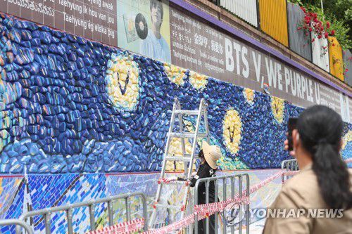 'BTS 뷔 벽화거리 보고 가세요'(대구=연합뉴스) 박세진 기자 = 20일 오전 BTS 맴버 '뷔(김태형)'의 모교인 대구 서구 비산동 대성초등학교 외벽에 '뷔 벽화거리' 연장 조성을 위한 막바지 작업이 진행 중이다. 2022.5.20 psjpsj@yna.co.kr