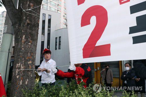 연이틀 광주서 현수막 거는 이준석 대표(광주=연합뉴스) 천정인 기자 = 국민의힘 이준석 대표가 21일 오전 광주 북구 신안동 한 거리에서 누군가에 의해 훼손된 국민의힘 후보의 현수막을 다시 걸고 있다.   2022.5.21 iny@yna.co.kr