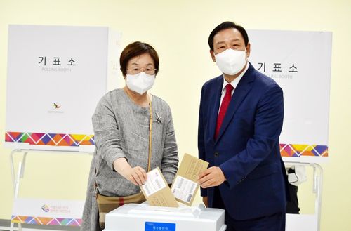 사전투표하는 최민호 국민의힘 세종시장 후보 부부   (세종=연합뉴스) 이은파 기자 = 최민호 국민의힘 세종시장 후보가 사전투표 첫날인 27일 오전 아름동복합커뮤니티센터에 마련된 투표소에서 아내 전광희 씨와 함께 사전투표를 하고 있다. 2022.5.27