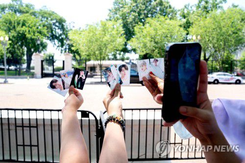 "우리 BTS가 백악관에 왔대요"(워싱턴 AFP=연합뉴스) 세계적인 K팝 스타 방탄소년단(BTS)이 백악관을 방문한 31일(현지시간) 팬들이 백악관 밖에서 BTS를 기다리며 멤버들의 사진을 촬영하고 있다. BTS는 미국 '아시아·하와이 원주민·태평양 제도 주민(AANHPI) 유산의 달' 마지막 날인 이날 조 바이든 미국 대통령과 면담하고 '반(反) 아시안 증오범죄 대응 방안'에 대해 의견을 교환했다.