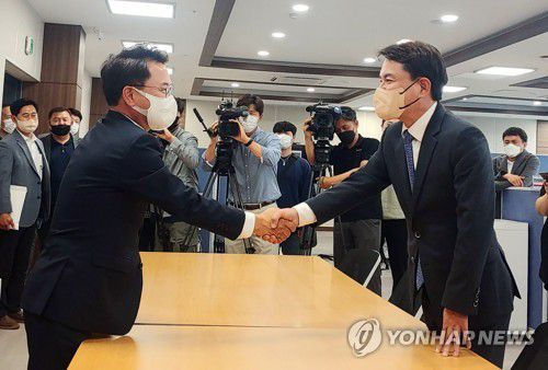 국민의힘 김진태(오른쪽) 강원도지사 당선인과 더불어민주당의 육동한 춘천시장 당선인이 8일 오후 강원도청 2청사 도지사직 인수위원회 사무실에서 만나 악수하고 있다. [연합뉴스 자료사진]