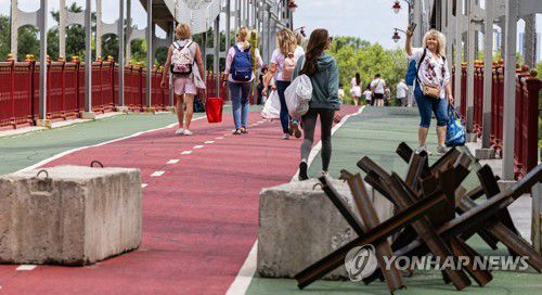 전쟁 중이지만 소풍 나온 키이우 시민들(키이우=연합뉴스) 황광모 기자 = 17일(현지시간) 우크라이나 수도 키이우를 흐르는 드네프르강 도보교에서 친구들과 소풍 나온 시민들이 기념 촬영을 하고 있다. 2022.6.17 hkmpooh@yna.co.kr