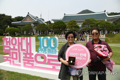 '청와대 100만 번째 관람객 됐어요'(서울=연합뉴스) 22일 오후 청와대 대정원에서 열린 '100만 번째 청와대 관람객' 기념행사에서 100만 번째 관람객으로 선정된 김영순 씨가 기념품으로 받은 대통령 기념 시계를 들고 기념촬영을 하고 있다. 2022.6.22 [문화재청 제공. 재판매 및 DB 금지] photo@yna.co.kr