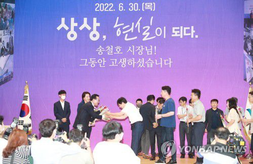 이임하는 송철호 울산시장(울산=연합뉴스) 30일 오전 울산시청 대강당에서 열린 민선 7기 송철호 울산시장 이임식에서 송 시장이 직원들에게 장미꽃을 받으며 인사를 나누고 있다. 2022.6.30 [울산시 제공. 재판매 및 DB 금지] hkm@yna.co.kr