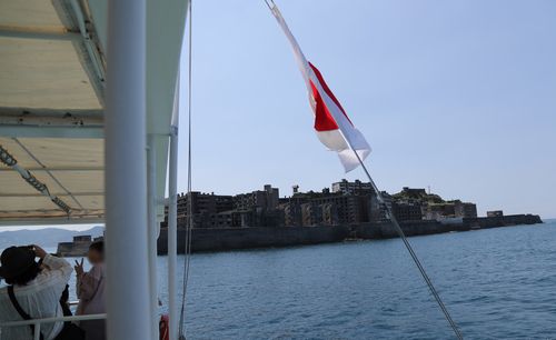 꼬인 일장기와 군함도(하시마=연합뉴스) 이세원 특파원 = 1일 오전 일본 나가사키현 하시마(일명 '군함도') 인근 해상을 운항 중인 유람선에서 관광객이 군함도를 배경으로 기념사진을 찍고 있다. 유람선에 설치된 일장기가 줄에 휘감겨 꼬여 있다.