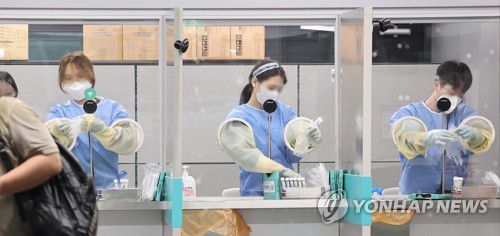 다시 분주해진 의료진(영종도=연합뉴스) 임헌정 기자 = 신규 확진자 수가 두 달여 만에 4만명대로 급증하고 해외 유입 신규 확진자도 역대 두번째로 많은 398명을 기록한 13일 오전 영종도 인천국제공항 제1여객터미널 입국자 전용 코로나19 검사 센터에서 의료진이 다음 검사자를 위해 주변을 정리하고 있다. 2022.7.13 kane@yna.co.kr