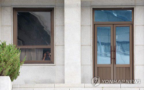 카메라 든 북한군(파주=연합뉴스) 이지은 기자 = 판문점 공동경비구역(JSA) 견학이 재개된 가운데 19일 경기도 파주시 판문점 내 북측 판문각 창문 틈으로 북한군이 남측을 향해 카메라를 들고 있다. 2022.7.19 jieunlee@yna.co.kr