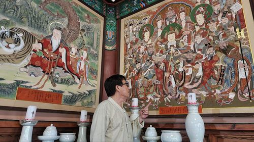 탱화 살펴보는 단청장 기능보유자 권현규씨(청주=연합뉴스) 윤우용 기자 = 충북도 무형문화재 제9호 단청장 기능 보유자 권현규씨가 청주 복천암 극락보전에 걸린 탱화를 살펴보고 있다. 2022.8.19  ywy@yna.co.kr (끝)