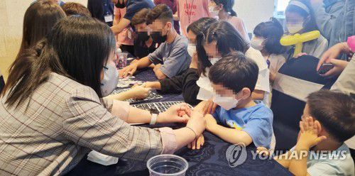 헤나 체험하는 아프간 특별기여자 자녀들(울산=연합뉴스) 김근주 기자 = 어린이날 100주년인 5월5일 울산 호텔현대 바이 라한에서 아프간 특별기여자 가정을 위한 행사가 열렸다. 어린이가 헤나 체험에 참여한 모습. 2022.5.5 canto@yna.co.kr