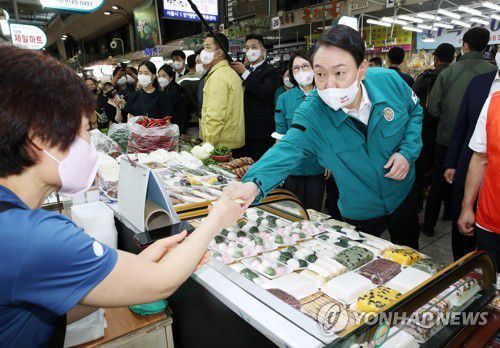 전통시장에서 떡 구입하는 윤석열 대통령(서울=연합뉴스) 서명곤 기자 = 윤석열 대통령이 25일 오전 서울 강동구 암사종합시장을 방문, 떡을 구입하고 있다. 2022.8.25 seephoto@yna.co.kr