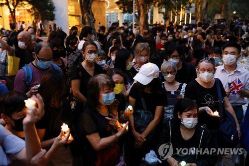 (로이터=연합뉴스) 지난 19일 저녁 홍콩 주재 영국 총영사관 앞에 모여든 엘리자베스 2세 영국 여왕의 추모객들. 2022.9.20.