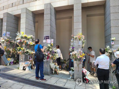 홍콩의 엘리자베스 2세 영국 여왕 추모 행렬[촬영 윤고은] 지난 13일 홍콩 주재 영국 총영사관 앞을 찾은 엘리자베스 2세 영국 여왕 조문객들과 그들이 놓고 간 꽃들. 2022.9.24.
