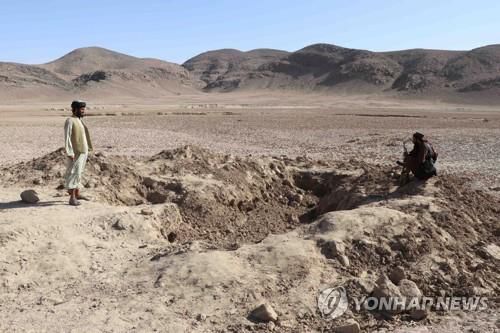 아프간 스핀볼다크의 시신 집단 매장지를 살펴보는 탈레반과 주민.[EPA 연합뉴스 자료사진. 재판매 및 DB 금지]