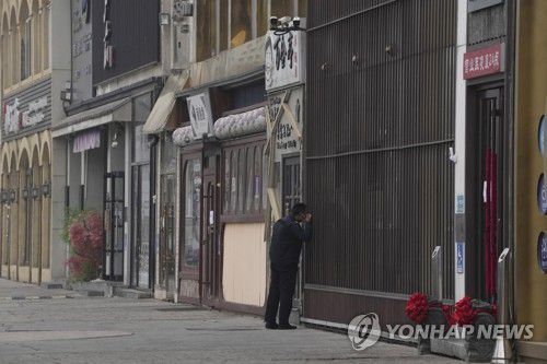 고강도 방역정책으로 텅 빈 베이징 거리(베이징 AP=연합뉴스) 24일(현지시간) 문 닫은 식당들이 줄지어 있는 중국 베이징의 한 거리에서 보안요원이 닫힌 상점 안을 들여다보고 있다. 베이징 방역당국은 최근 코로나19 확진자가 급증하자 일부 지역의 상점, 식당 등 공중 이용시설에 폐쇄 조치를 내렸다. 2022.11.24 clynnkim@yna.co.kr