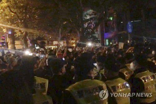 코로나19 봉쇄정책 반대 시위에 배치된 상하이 경찰들(상하이 AP=연합뉴스) 26일(현지시간) 중국 상하이에서 경찰들이 고강도 코로나19 봉쇄정책에 반대하는 시위를 벌이는 시민들을 지켜보고 있다. 지난 24일 신장웨이우얼자치구 우루무치시의 한 고층 아파트에서 발생한 화재 사건으로 '제로 코로나' 정책에 대한 시민들의 분노가 가열되면서 상하이를 비롯한 여러 도시에서 시위가 벌어지고 있다. 2022.11.27 jason3669@yna.co.kr