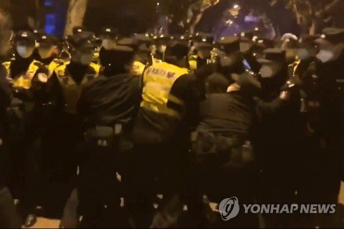 (AP=연합뉴스) 지난달 27일 중국 상하이에서 발생한 제로 코로나 반대 시위 현장에서 경찰이 사람들을 단속하는 모습. 2022.12.4.