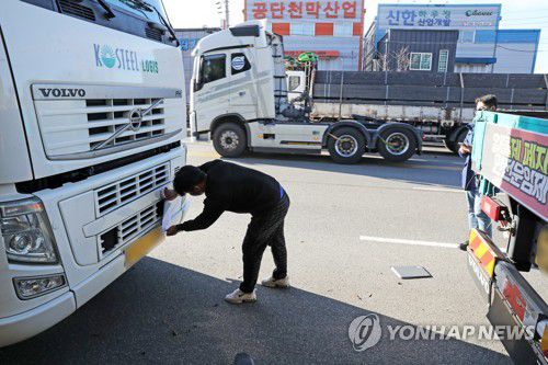 집단운송 거부행위 조사개시(포항=연합뉴스) 손대성 기자 = 정부가 8일 철강·석유화학 업종 운송거부자에 대한 업무개시명령을 발동한 가운데 국토교통부와 포항시 관계자가 이날 오후 경북 포항철강산업단지 갓길에 세워진 민주노총 화물연대 소속 조합원의 화물차에 '집단운송 거부행위 조사개시 통지서'와 '단속 예고장'을 붙이고 있다. 2022.12.8 sds123@yna.co.kr