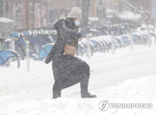 2022년 1월 29일 폭설 내린 뉴욕시 거리를 건너는 한 여성[UPI 연합뉴스 자료사진. 재판매 및 DB 금지]