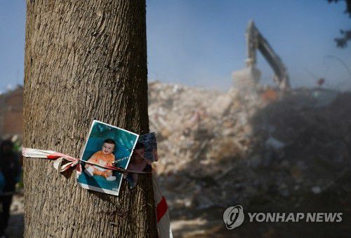 튀르키예 건물 잔해 옆 나무에 매달려 있는 아이 사진(카흐라만마라슈 로이터=연합뉴스) 14일(현지시간) 튀르키예 카흐라만마라슈의 무너진 건물 옆 나무에 아이 사진들이 매달려 있다. 지난 6일 시리아와 인접한 튀르키예 남동부에서 규모 7.8의 강진이 발생해 현재까지 양국에서 4만1천명 이상이 숨졌다. 2023.02.16 yerin4712@yna.co.kr